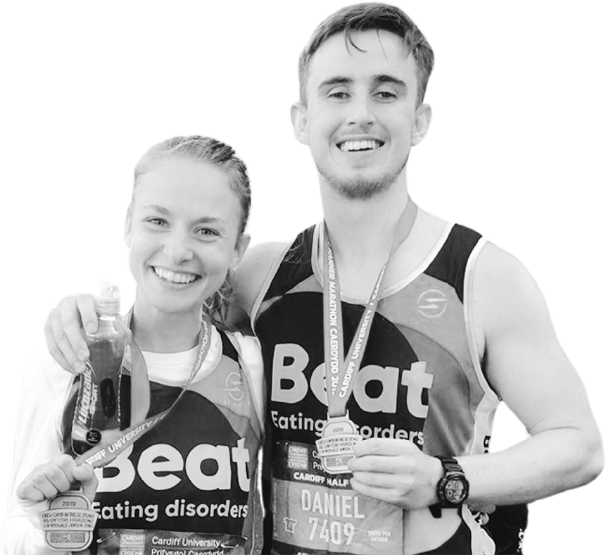 Two runners wearing Beat Eating Disorders running gear showing off medals.